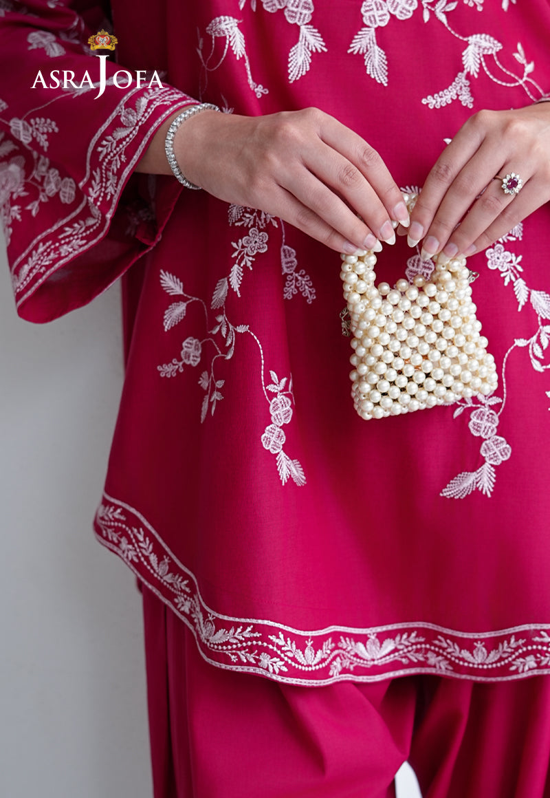 Asra Jofa ASAE-07 close-up detail of hot pink cambric kurta hem with white floral embroidery border and pearl bead bag accessory